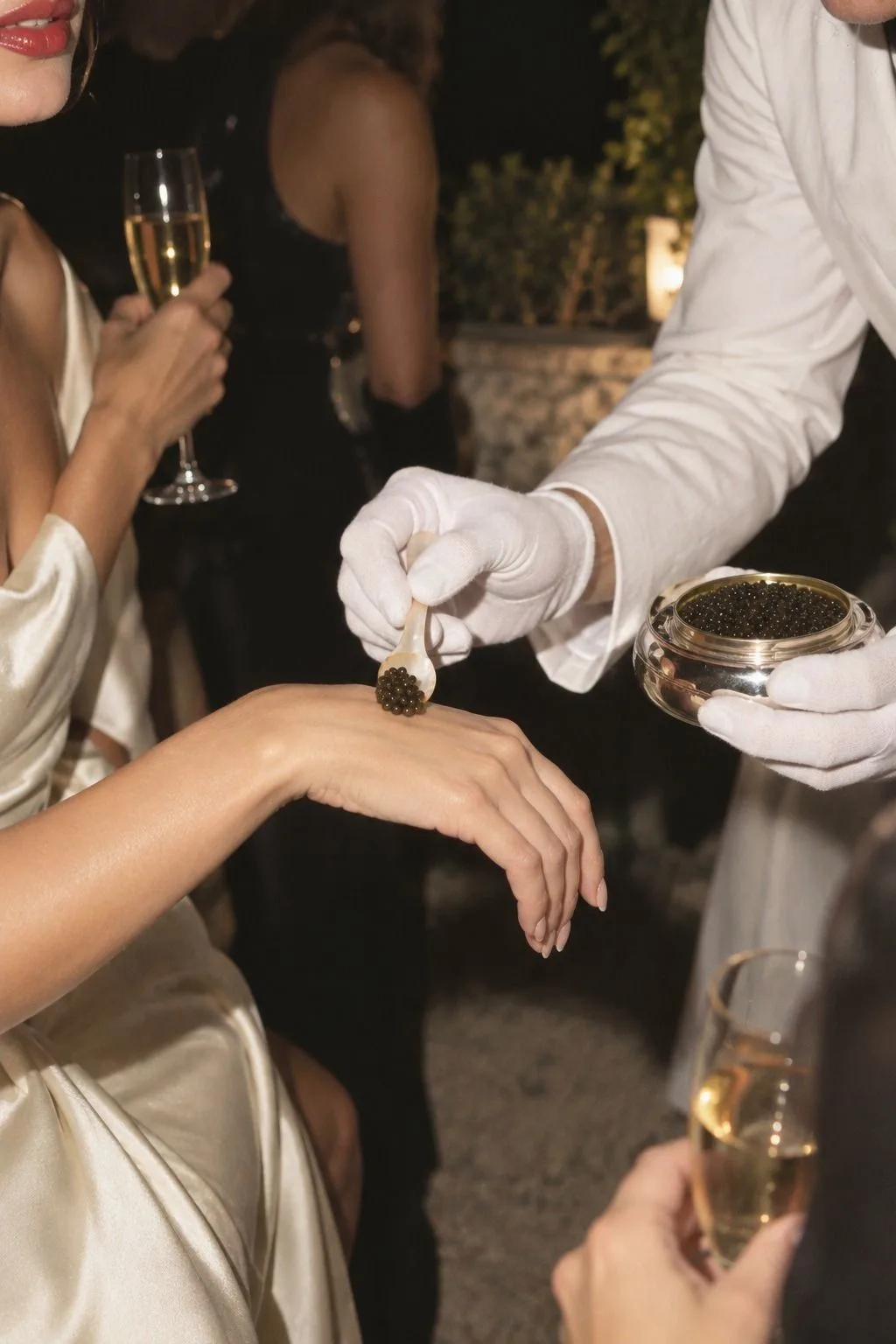 Hochzeit auf Mallorca: Kaviar wird mit einem Perlmuttlöffel auf dem Handrücken eines Gastes serviert