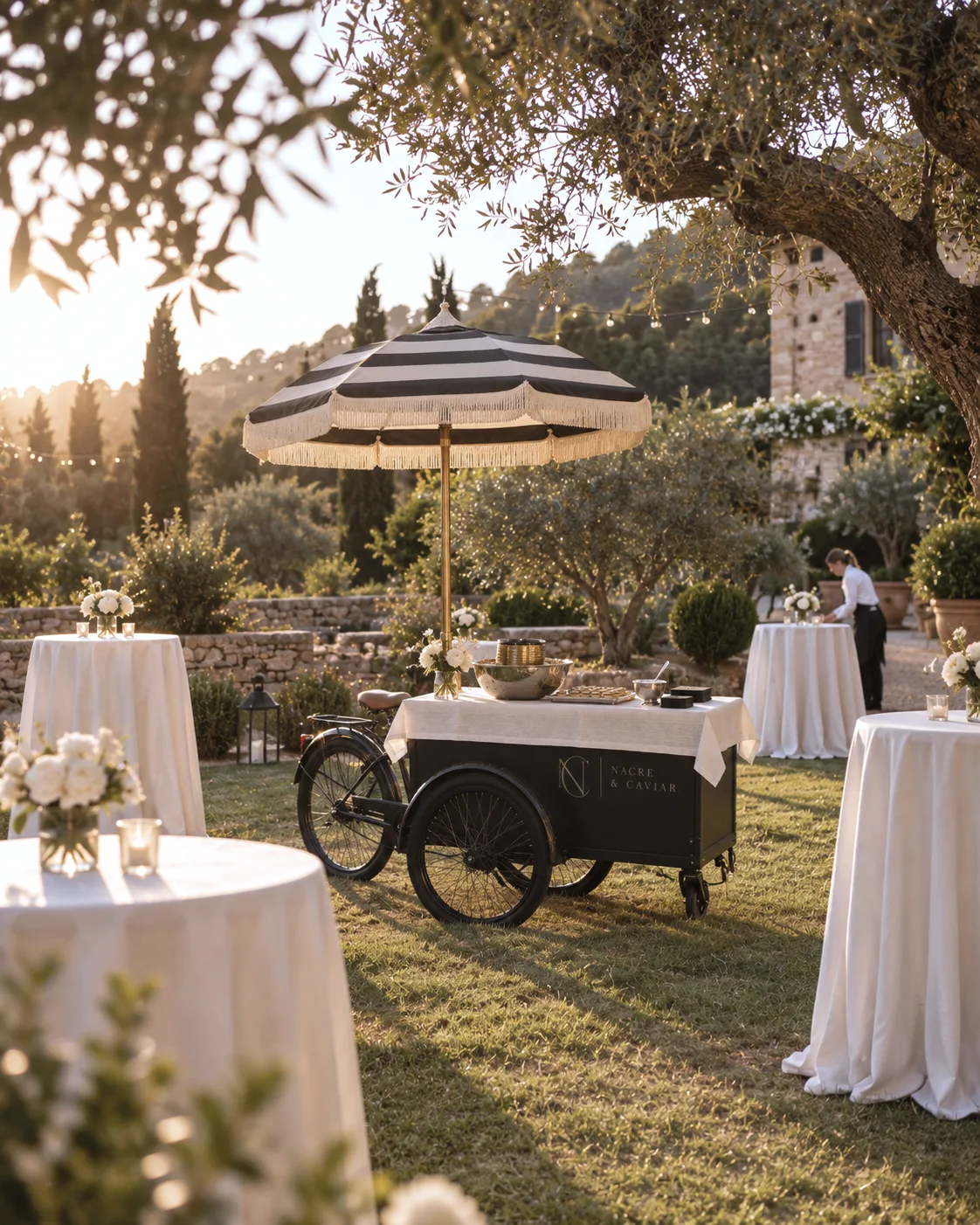Réception dans un jardin de Majorque au coucher du soleil, entre oliviers et parasols